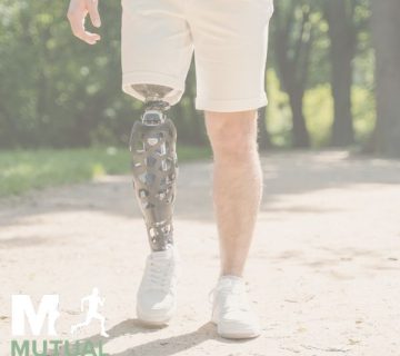 A person with a prosthetic leg walks on a dirt path in a park, wearing white shorts and sneakers "Mutual Orthopedics" logo appears in the bottom left corner
